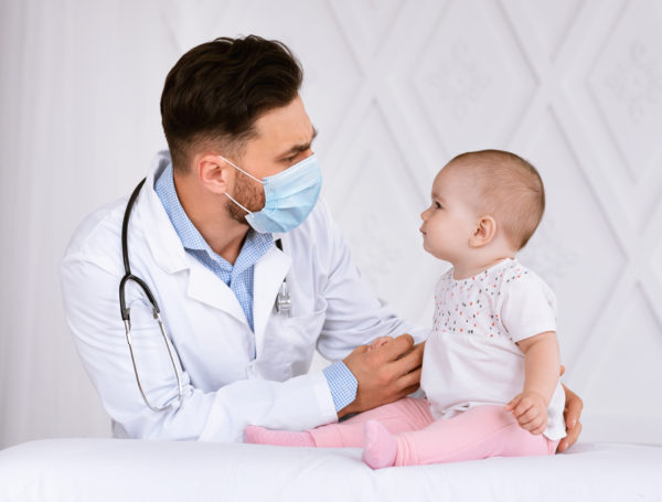 Doctor with face masks examines baby